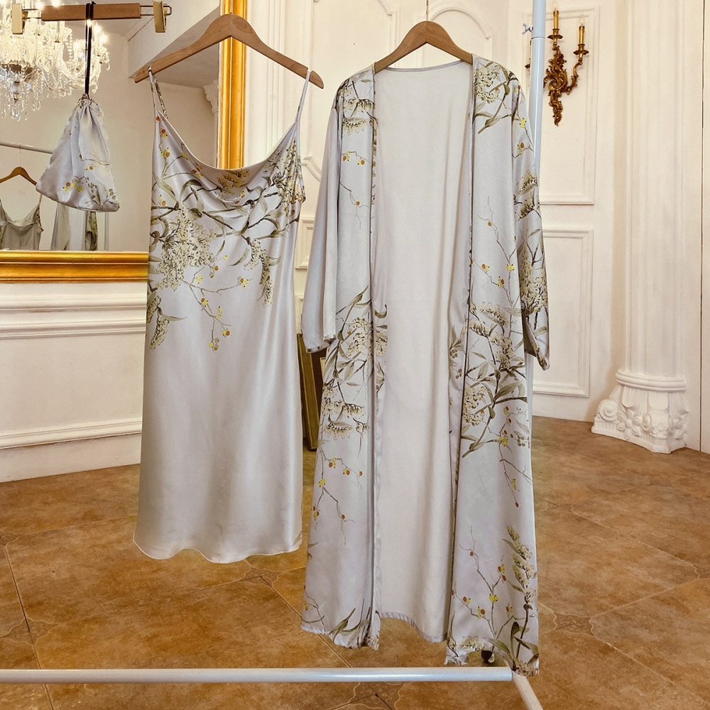 Pijama sexy gris con estampado floral colgado de una percha en una habitación con suelo de madera y pared blanca y delante de un gran espejo con marco dorado