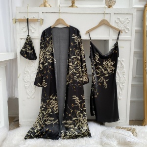 Sexy pijama negro con estampado floral colgado en perchas delante de una pared blanca con molduras y sobre una manta de piel blanca